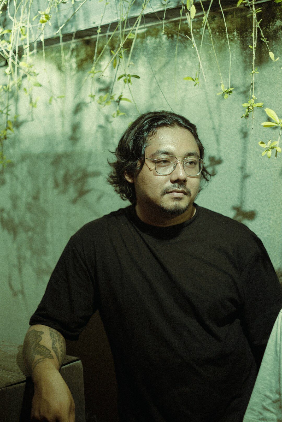 Studio portrait of a smiling Asian man in his thirties wearing glasses
