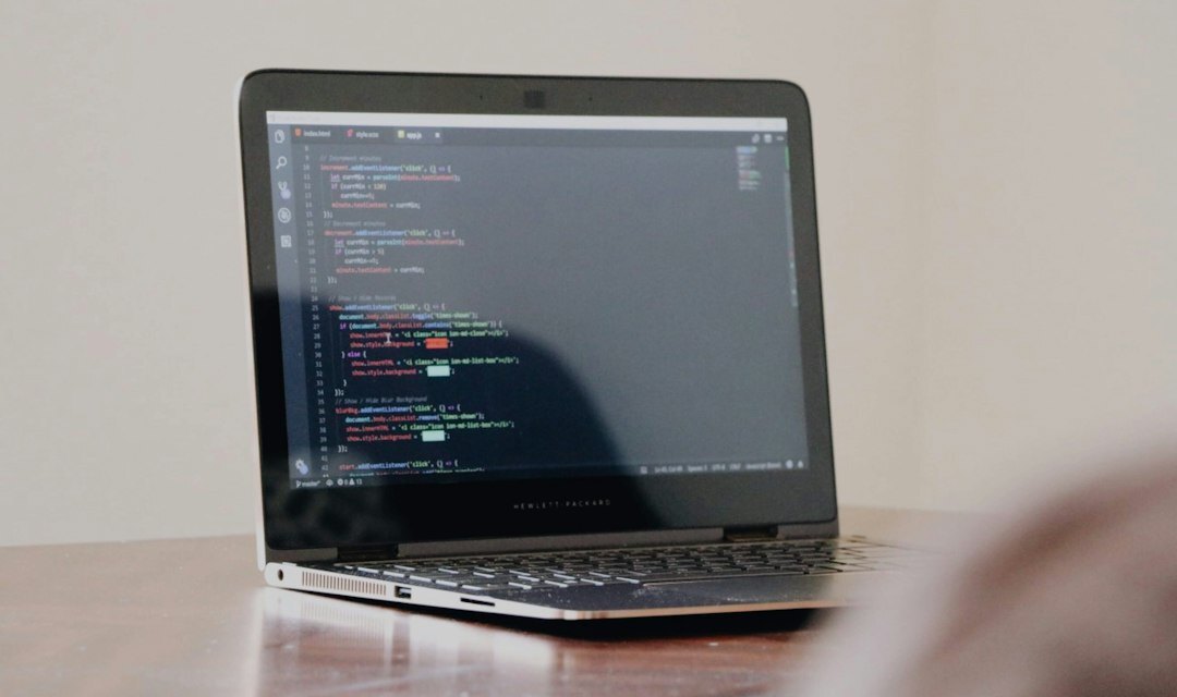 programmer writing code on laptop